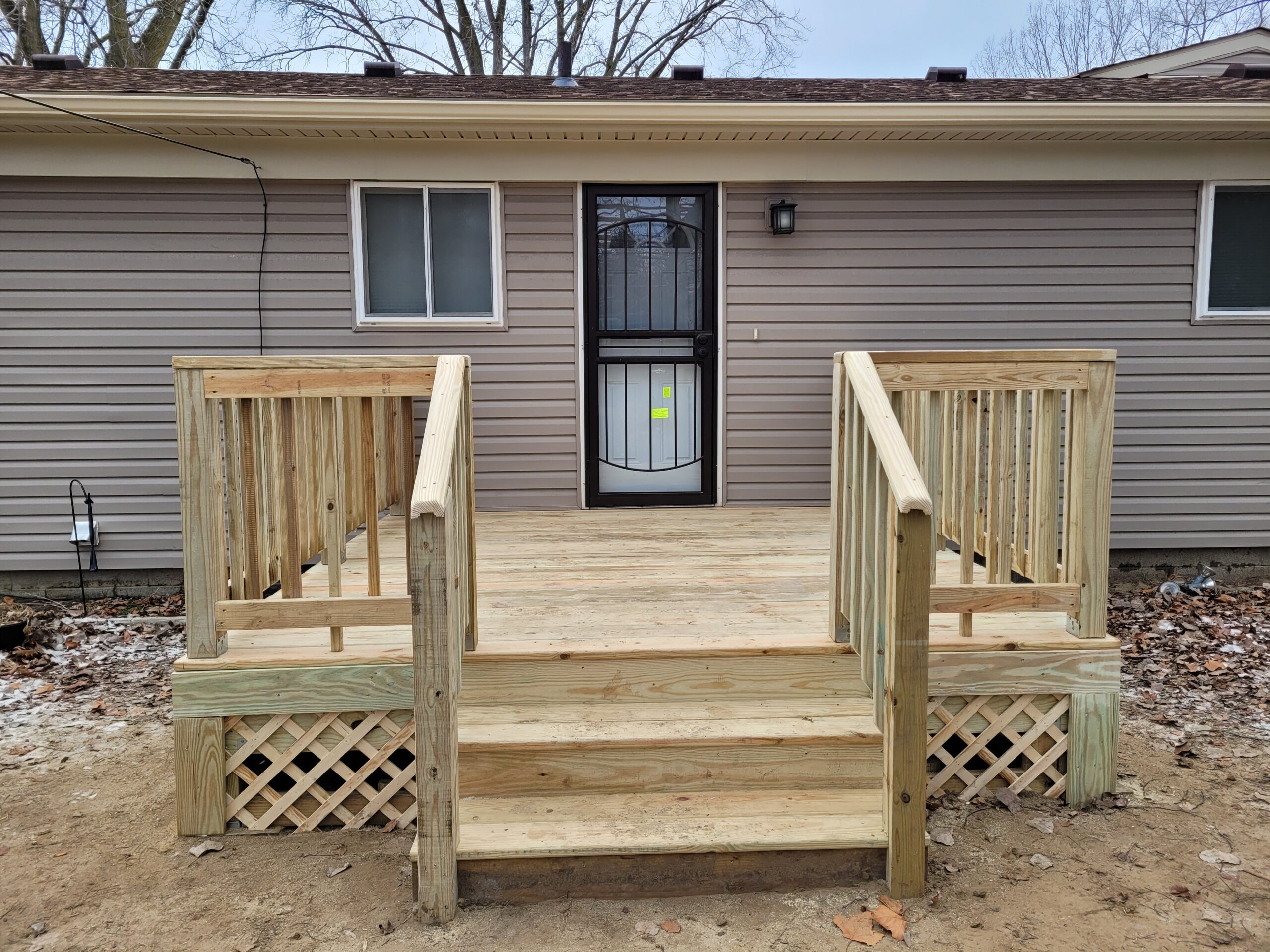 New treated-wood deck with railings in Southfield